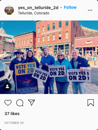 Members of the Telluride short-term rental alliance hold up signs in support of Ballot Measure 2D on Colorado short-term rental laws.